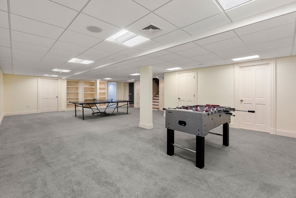 182 Winding River Road Wellesley, MA 02482 - Photo 34 of 40 a living room with furniture pool table and a fireplace