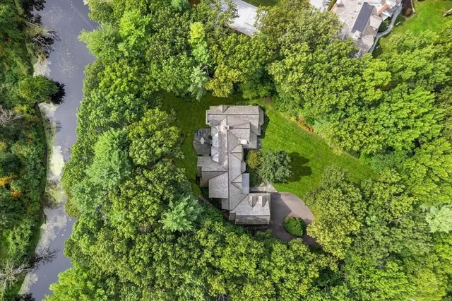 an aerial view of a house with a yard and large trees