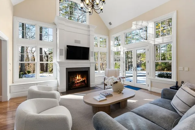 a living room with furniture a fireplace and a large window