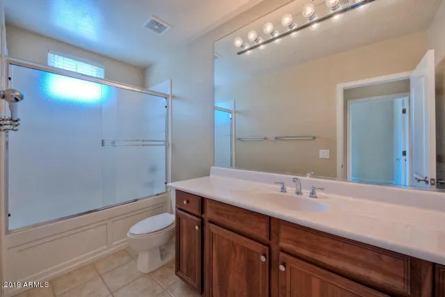 a bathroom with a sink a toilet a mirror and shower