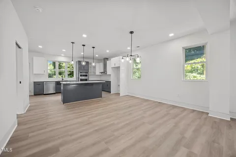 a kitchen with a table chairs stove and white cabinets