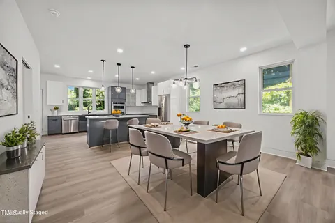 a large kitchen with a lot of cabinets and wooden floor