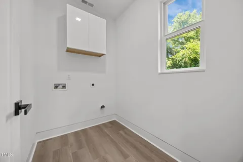 an empty room with wooden floor a ceiling fan and windows