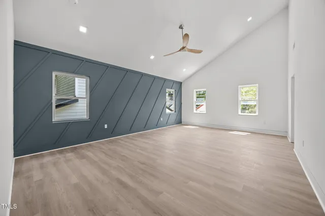 a spacious bedroom with a bed a couch and a chandelier