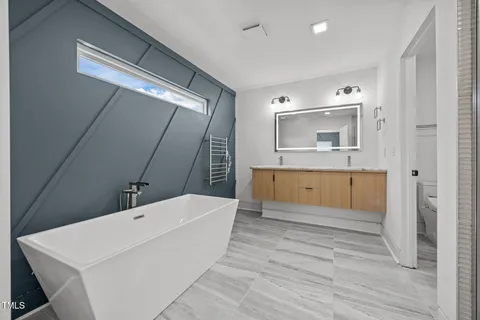 a bathroom with a tub sink and mirror