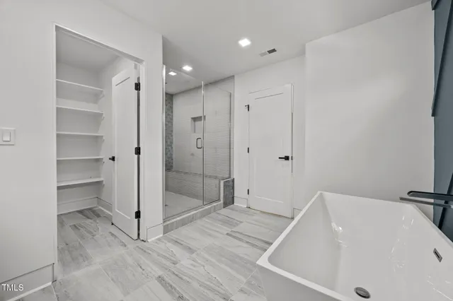 a view of an empty room with wooden floor and windows