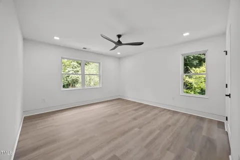 a bathroom with a granite countertop sink a toilet a mirror and shower