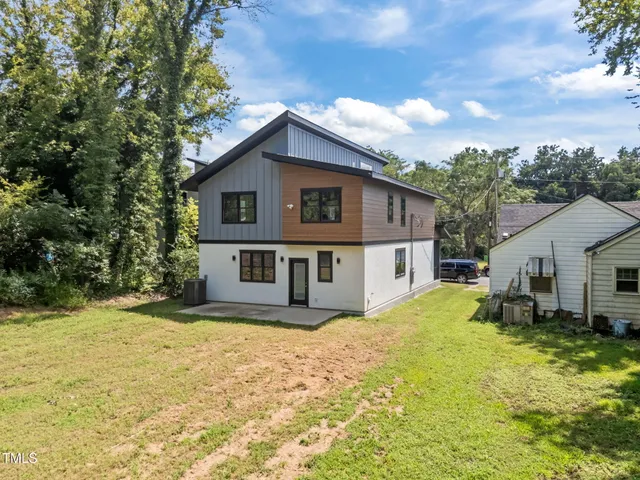 an aerial view of residential houses with outdoor space and ocean view