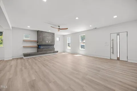 a view of empty room with wooden floor and window