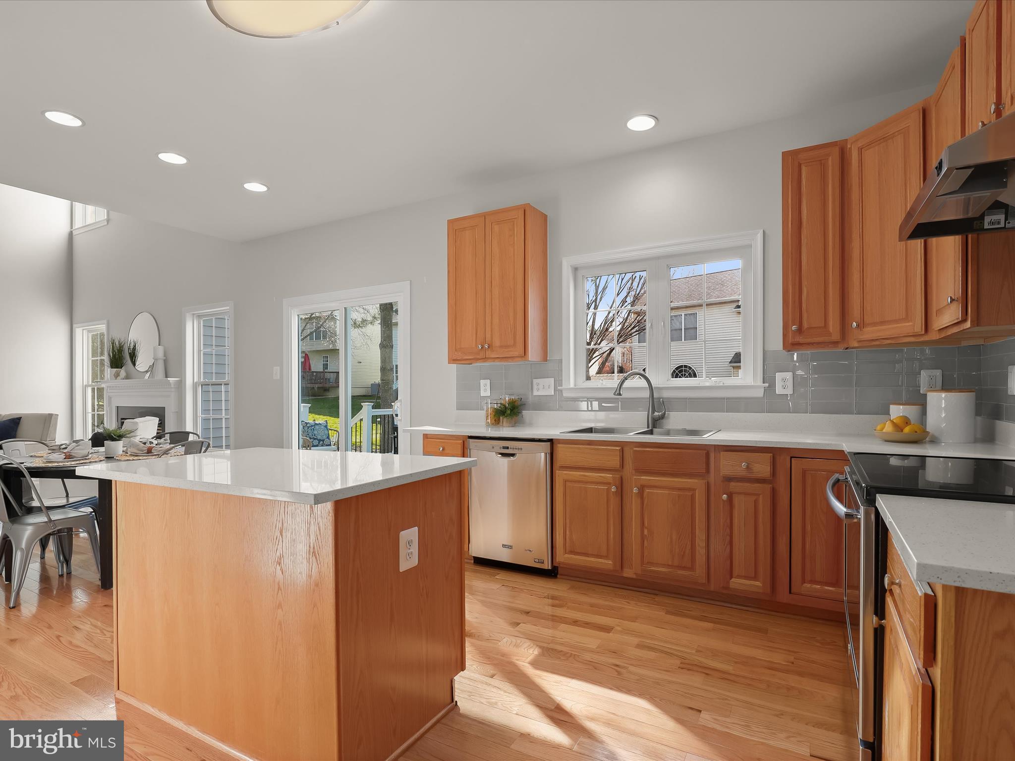 6413 Phantom Moon Walk Clarksville, MD 21029 - Photo 14 of 60 a kitchen with stainless steel appliances granite countertop wooden cabinets a sink a stove a dining table and chairs