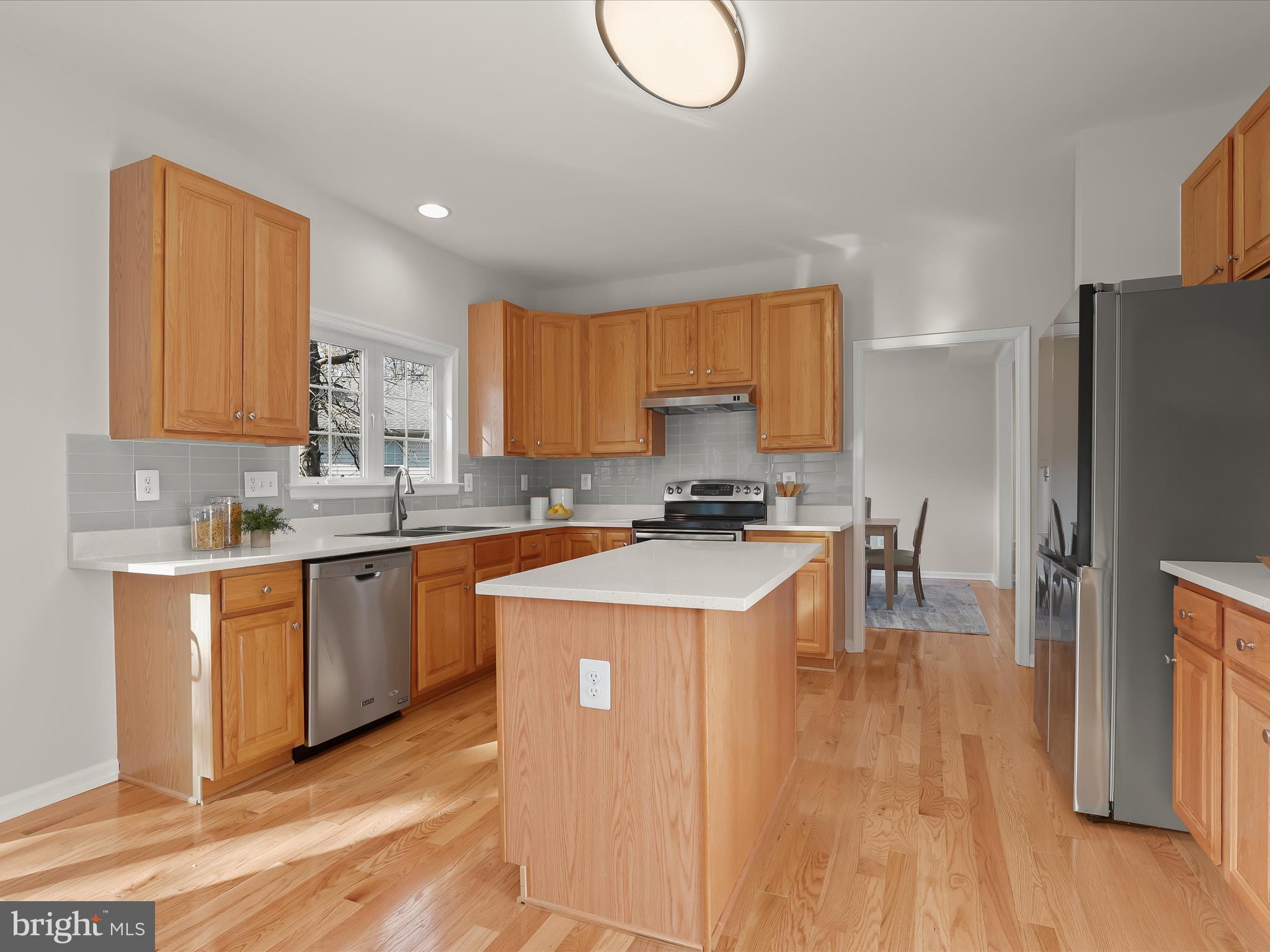6413 Phantom Moon Walk Clarksville, MD 21029 - Photo 16 of 60 a kitchen with a refrigerator a stove top oven a sink dishwasher and wooden cabinets