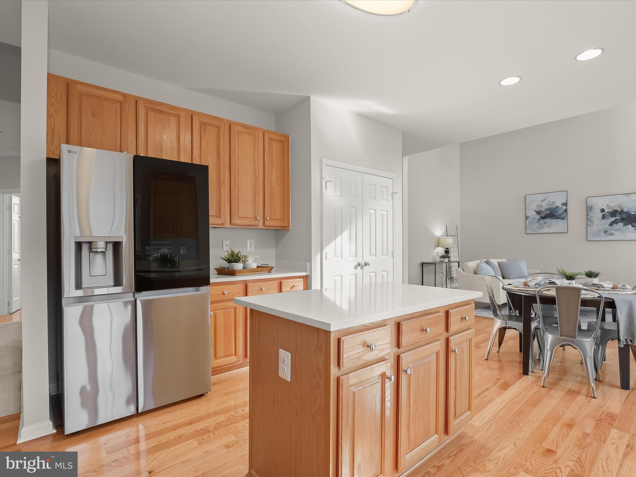 6413 Phantom Moon Walk Clarksville, MD 21029 - Photo 18 of 60 a kitchen with stainless steel appliances granite countertop a refrigerator a stove a sink a dining table and chairs with wooden floor