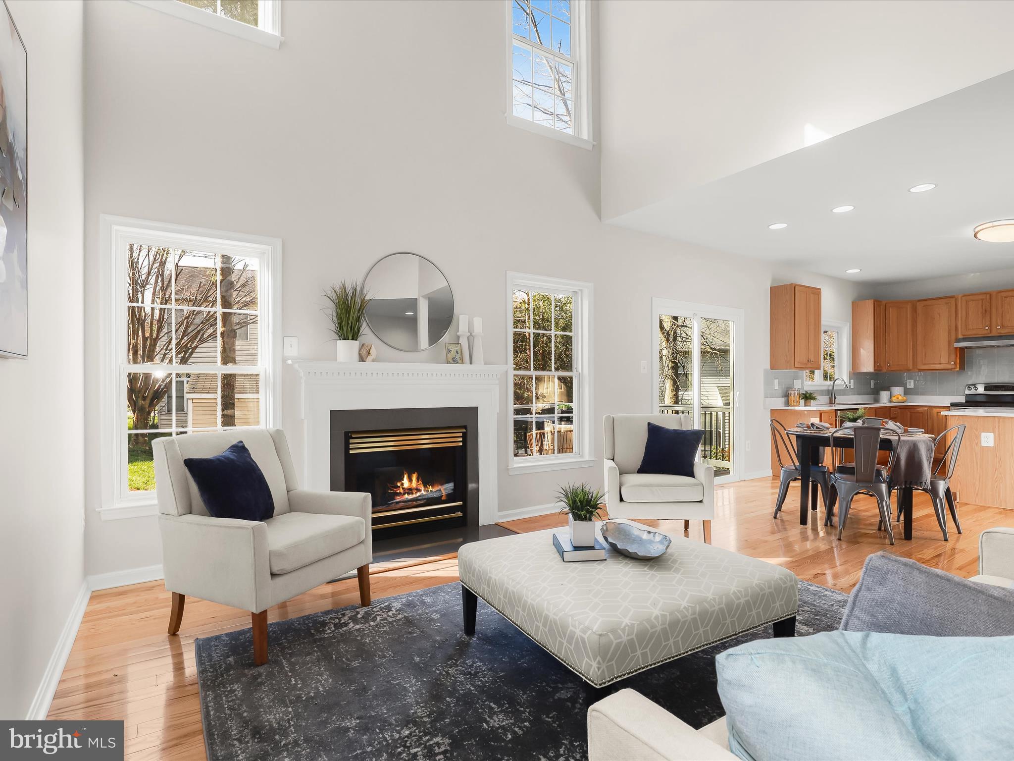 6413 Phantom Moon Walk Clarksville, MD 21029 - Photo 59 of 60 a living room with couches a fireplace and a dining table with wooden floor
