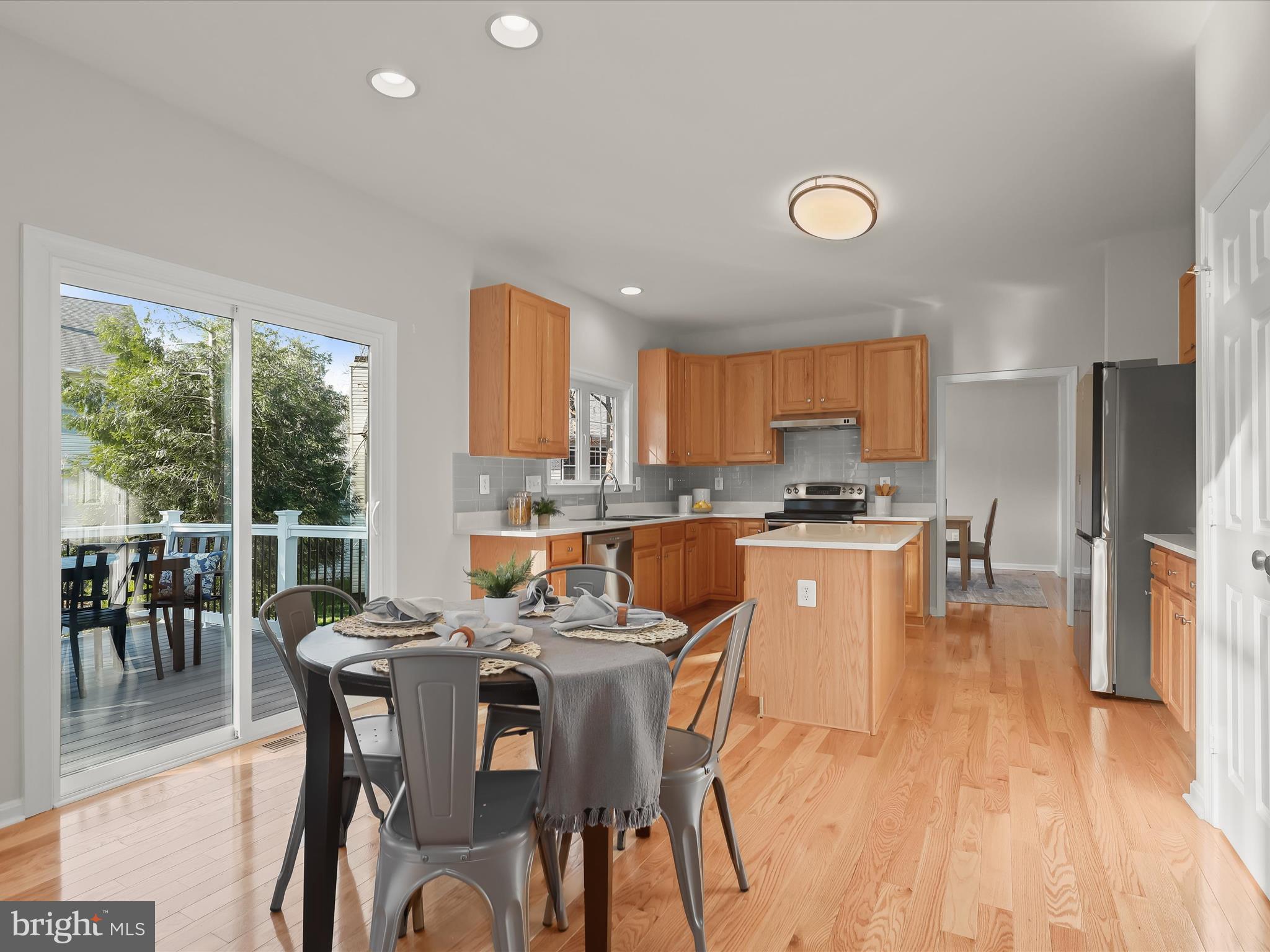6413 Phantom Moon Walk Clarksville, MD 21029 - Photo 2 of 60 a kitchen with stainless steel appliances granite countertop a stove top oven a sink dishwasher a dining table and chairs with wooden floor