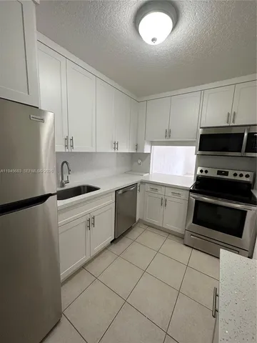 a kitchen with cabinets and white stainless steel appliances