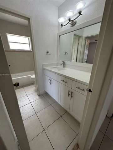 a spacious bathroom with a granite countertop sink a mirror and a vanity