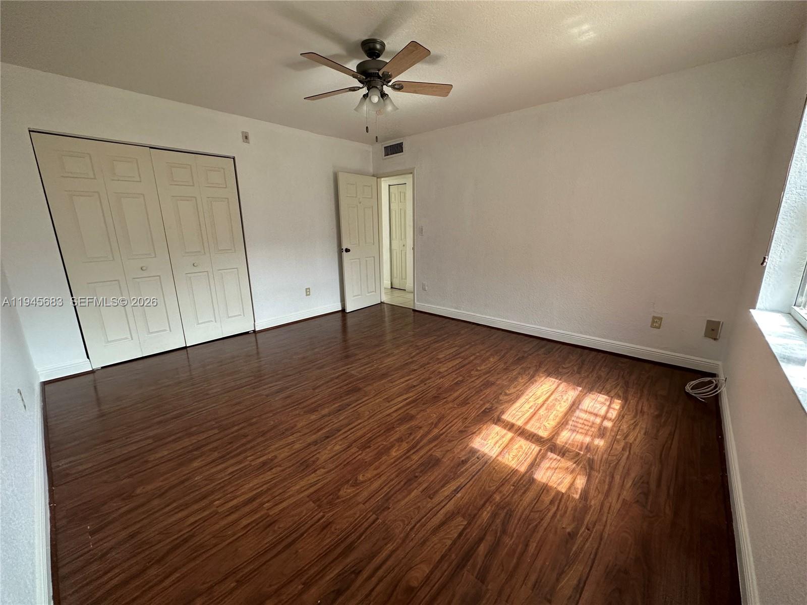 9972 Southwest 88th Street, Unit 1121 Miami, FL 33176 - Photo 4 of 7 a view of an empty room with wooden floor and a window