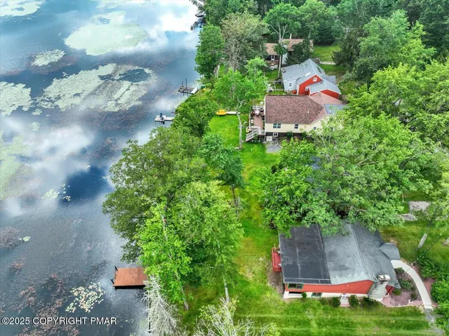 an aerial view of residential houses with outdoor space and lake view