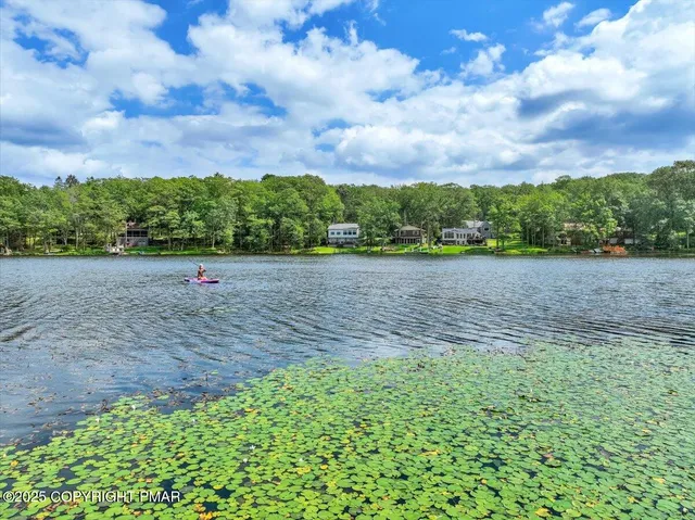 a living room with furniture appliances and a open kitchen view