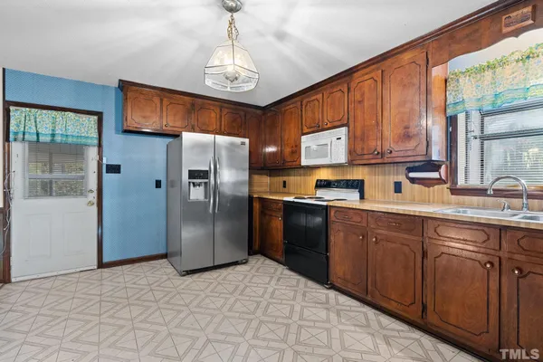 a kitchen with stainless steel appliances granite countertop a refrigerator and a sink