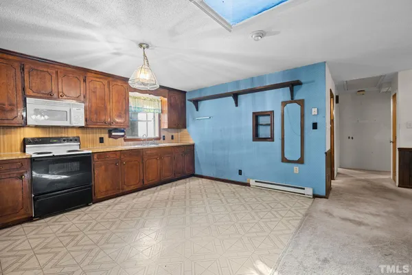 a kitchen with granite countertop a refrigerator stove top oven and sink