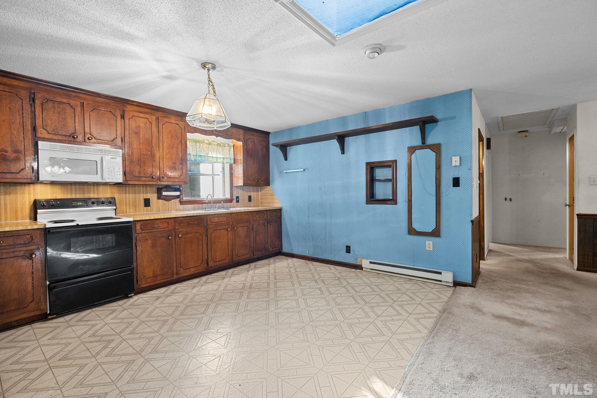 5930 Guess Road Durham, NC 27712 - Photo 12 of 43 a kitchen with granite countertop a refrigerator stove top oven and sink