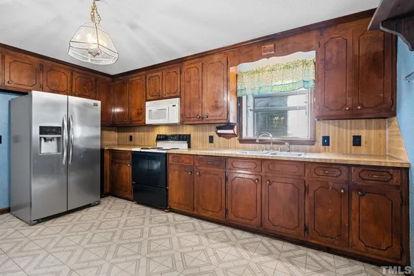a kitchen with stainless steel appliances granite countertop a refrigerator and a sink