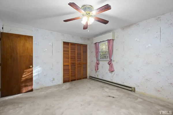 an empty room with windows and fan