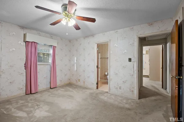 an empty room with closet and a ceiling fan