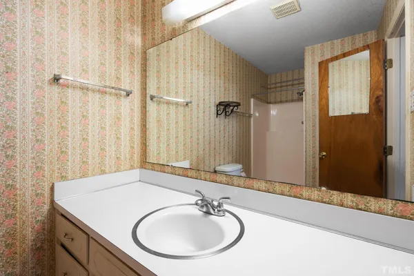 a bathroom with a sink a mirror and a shower