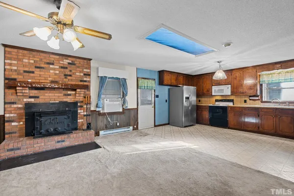 a large kitchen with stainless steel appliances granite countertop a refrigerator a oven a sink with a dining table and chairs