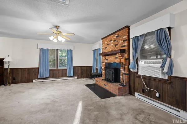 a view of a livingroom with a fireplace and workspace