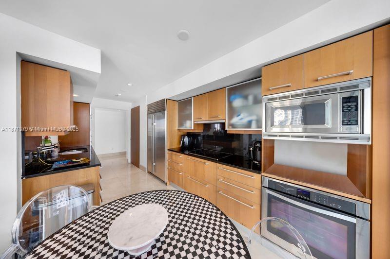 1331 Brickell Bay Drive, Unit 1602 Miami, FL 33131 - Photo 27 of 44 a kitchen with stainless steel appliances kitchen island granite countertop a stove and cabinets