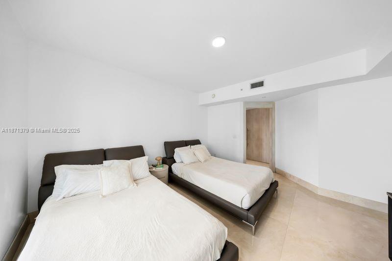 1331 Brickell Bay Drive, Unit 1602 Miami, FL 33131 - Photo 30 of 44 a bedroom with a bed and a night stand