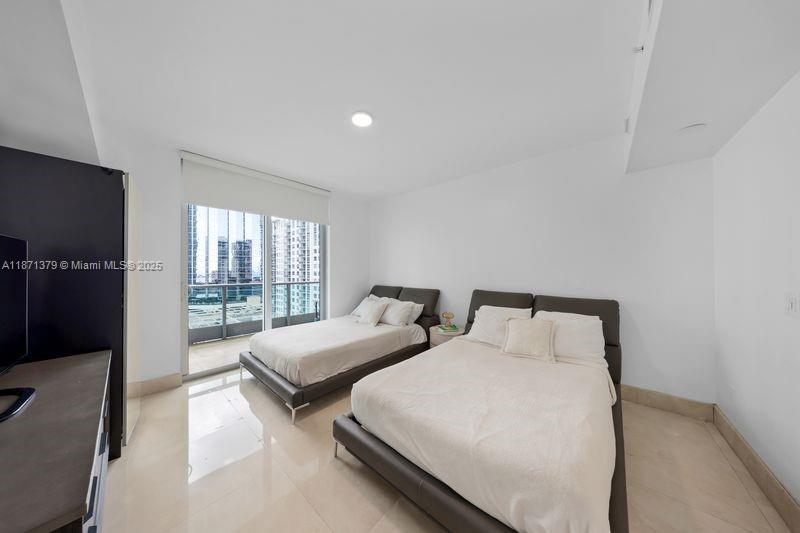 1331 Brickell Bay Drive, Unit 1602 Miami, FL 33131 - Photo 31 of 44 a bedroom with two beds and a flat screen tv