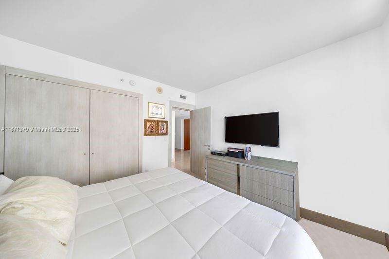 1331 Brickell Bay Drive, Unit 1602 Miami, FL 33131 - Photo 40 of 44 a bedroom with a bed and a flat screen tv