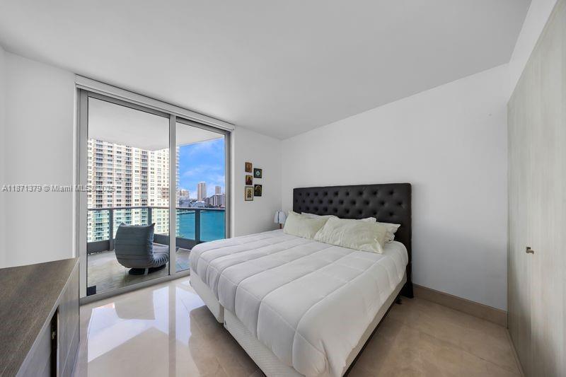 1331 Brickell Bay Drive, Unit 1602 Miami, FL 33131 - Photo 41 of 44 a bedroom with a large bed and wooden floor