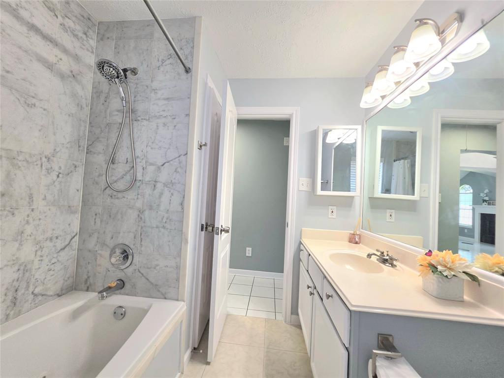 13618 Sablegrove Lane Houston, TX 77014 - Photo 22 of 30 a spacious bathroom with a tub sink shower and mirror