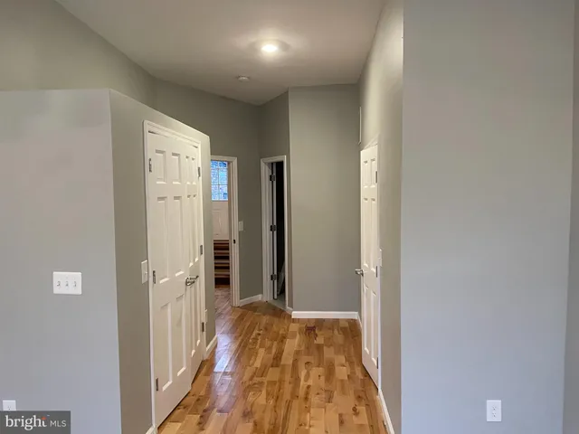 a view of a kitchen with kitchen island a sink wooden floor and a counter top space