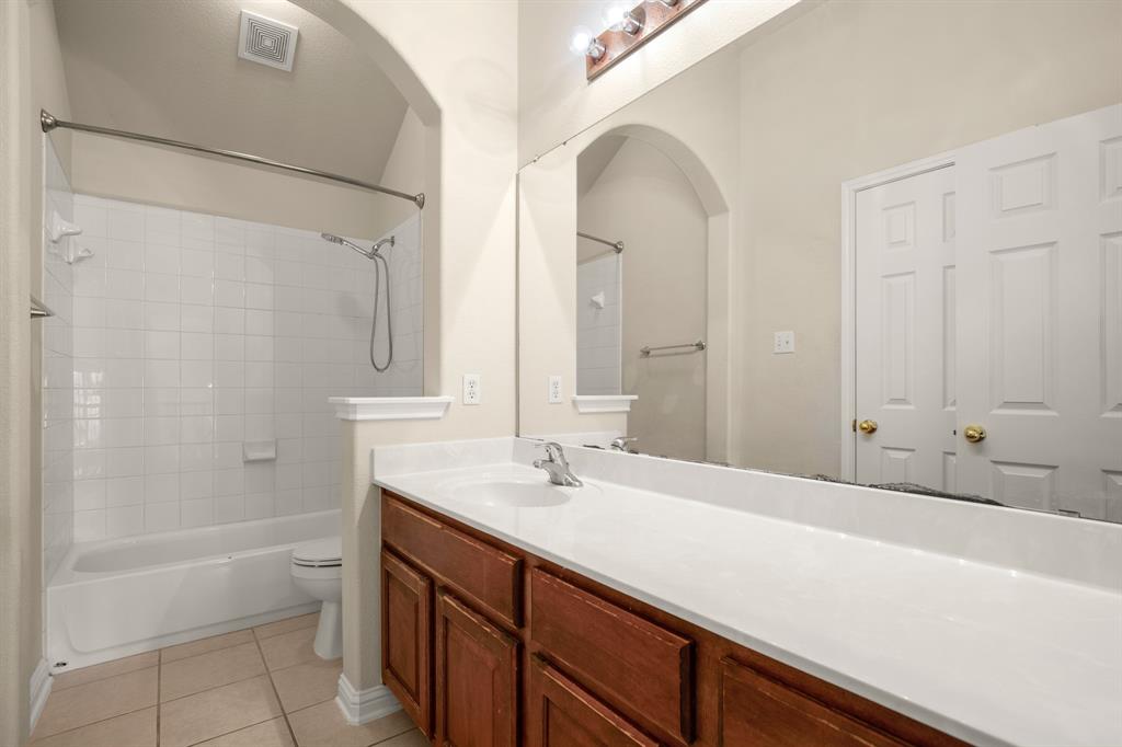 10105 Wind Cave Trail Austin, TX 78747 - Photo 19 of 23 Bathroom vanity featuring a single sink, light-toned countertop, and wood-finish cabinetry