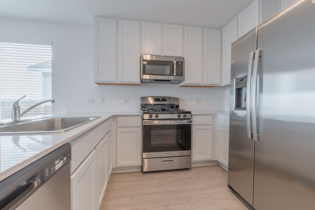 216 Little Sparklers Loop Hutto, TX 78634 - Photo 9 of 39 a kitchen with a sink and stainless steel appliances
