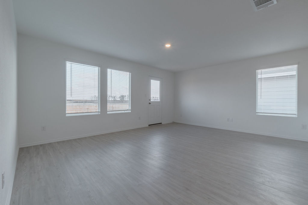 216 Little Sparklers Loop Hutto, TX 78634 - Photo 12 of 39 a view of an empty room with a window and wooden floor