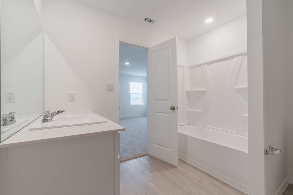 216 Little Sparklers Loop Hutto, TX 78634 - Photo 31 of 39 a bathroom with a tub sink vanity and a mirror
