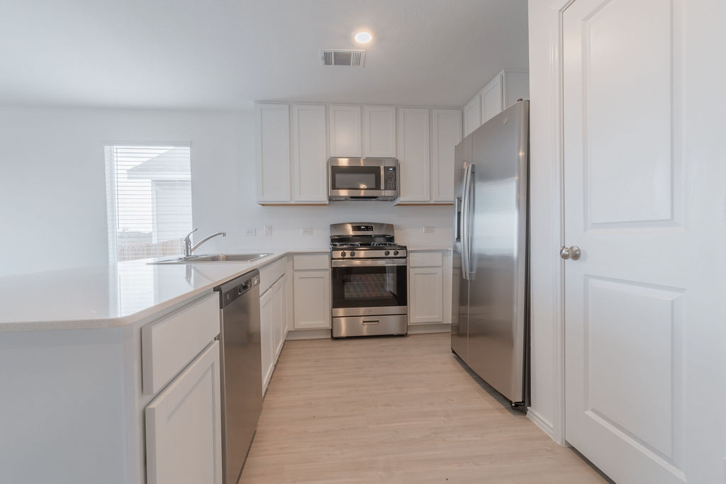 216 Little Sparklers Loop Hutto, TX 78634 - Photo 7 of 39 a kitchen with stainless steel appliances a refrigerator and a sink