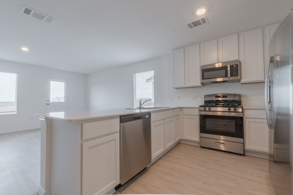 216 Little Sparklers Loop Hutto, TX 78634 - Photo 8 of 39 a kitchen with granite countertop a stove and a sink