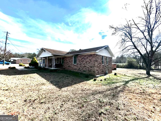 a front view of a house with a yard covered with snow