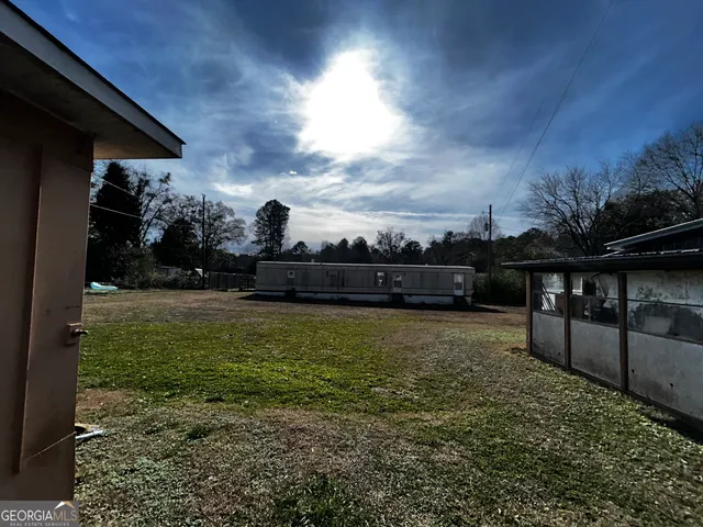 a view of a backyard with wooden fence and a bench