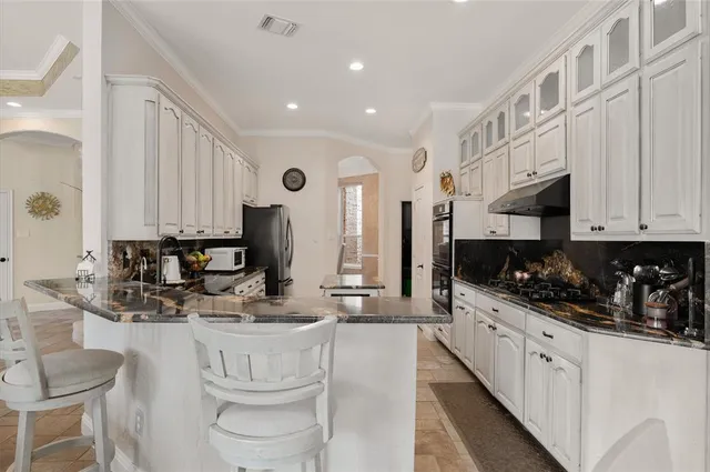 a kitchen with stainless steel appliances kitchen island granite countertop a sink and cabinets