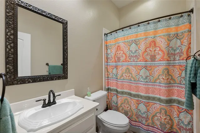 a bathroom with a sink a mirror and a shower curtain