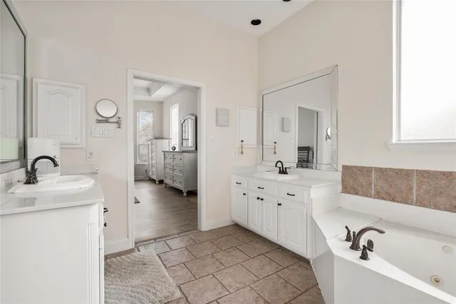 a bathroom with a tub sink and mirror